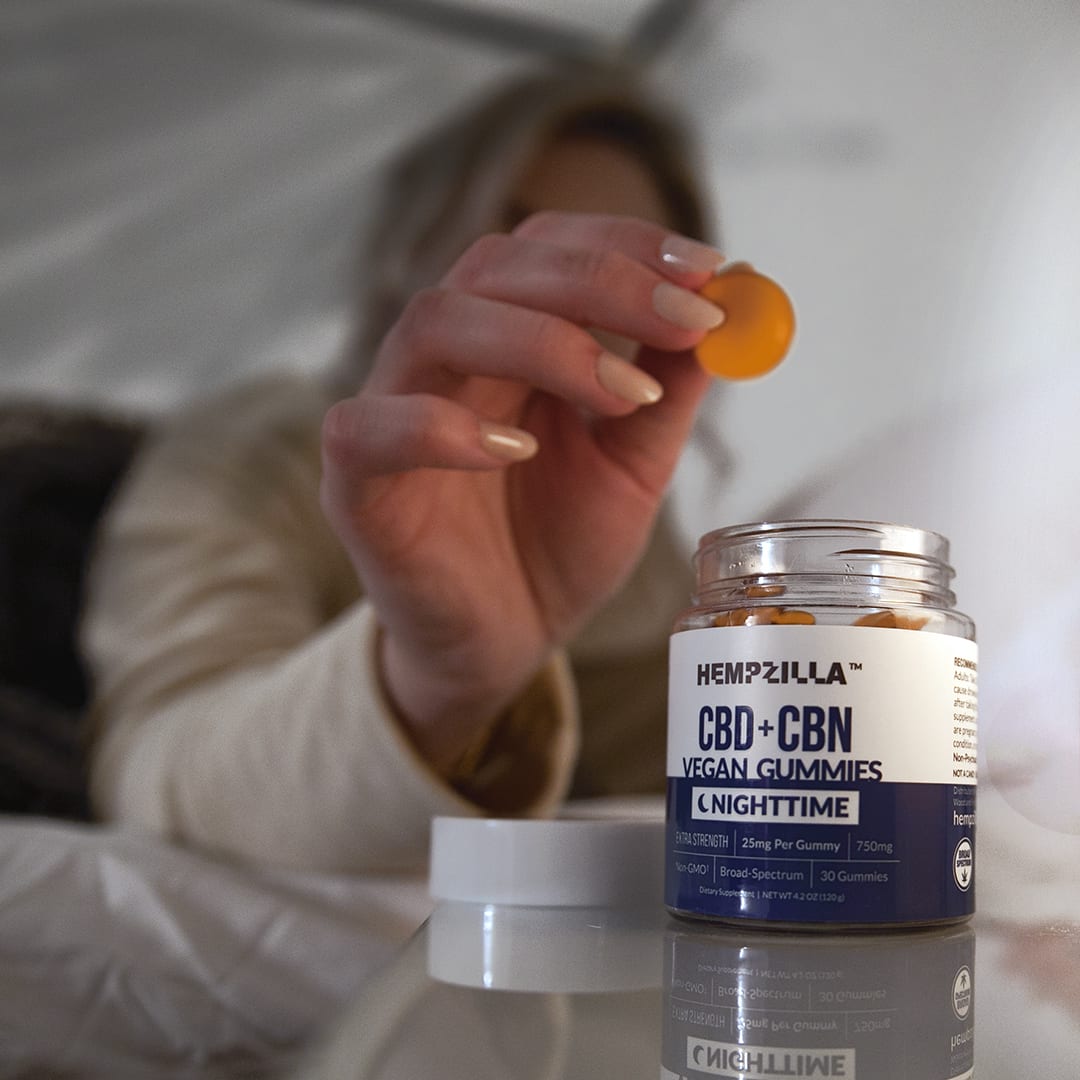 Woman taking orange gummies for sleep trouble